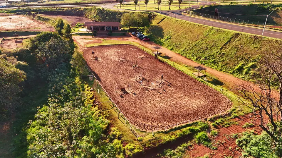 Vista aérea do centro hípico com a área de acesso, o estacionamento e a pista